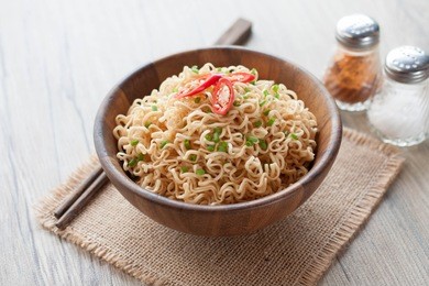 instant noodles in wooden bowl on wood background