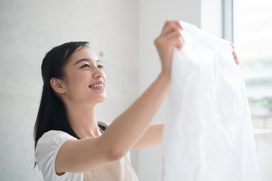 young woman holding clean laundry