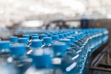 water factory - water bottling line for processing and bottling pure spring water into small bottles. selective focus.
