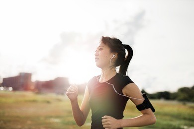 outdoor shot of young fitness woman running in the park. chinese female running exercising in morning.