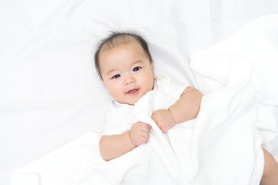 portrait of a newborn asian baby on the bed 