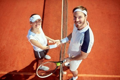 sportsman and sportswoman shaking hands on tennis court