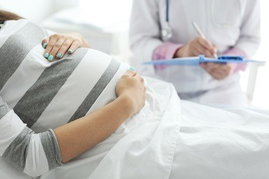 young pregnant woman with doctor at the hospital