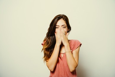 girl laughs and covers her mouth
