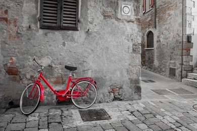 old mediterranean town street with red retro bike and sunlight - vintage toned, italy, europe