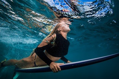 slim surfer blonde model in bikini with surf board dive underwater with joy under ocean surface. family lifestyle, people sea water sport lessons and beach swimming activity on summer vacation