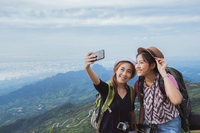 asian tourists are enjoying the selfie with friends. they have come to the mountains of phu tubberk