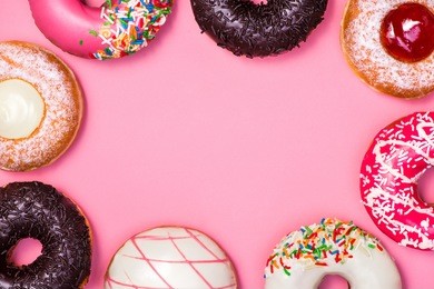 donuts with icing on pastel pink background. sweet donuts.