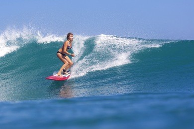 surfer girl on amazing blue wave, bali island.