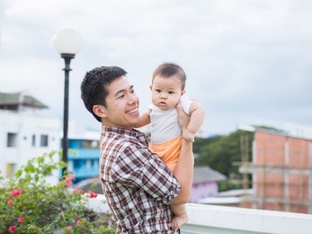 father is carrying his son. he loves his son so much. his son always happy when he is held.