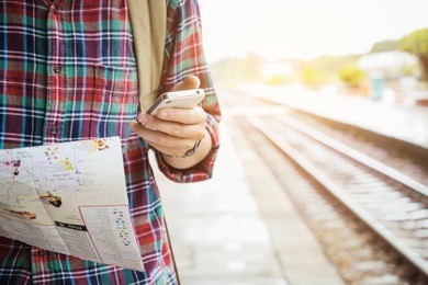 young tourist holding a map  and using mobile phone travel concept