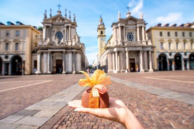 holding italian chocolate with bow on turin city background. turin in piedmont region in italy is famous of its chocolate making
