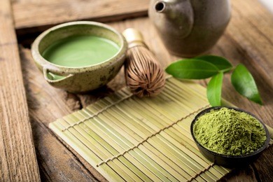 matcha fine powdered green tea on wooden background.