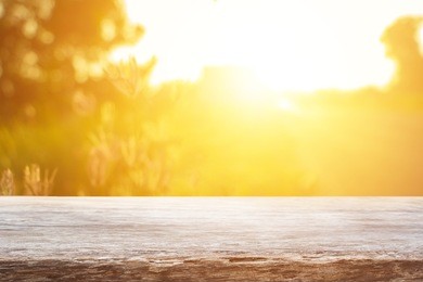 empty wooden table with autumn for a catering or food background with a country outdoor theme,template mock up for display of product,blurred grass in bright morning.