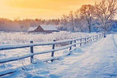rural house with a fence in winter. village after snowfall