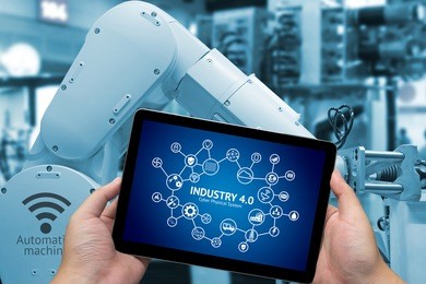 industrial internet of things concept .man hand holding tablet with infographic industry4.0 icons screen and blue tone of automate wireless robot arm in smart factory background