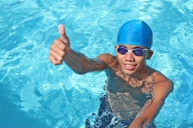 young asian swimmer making a thumbs up for victory