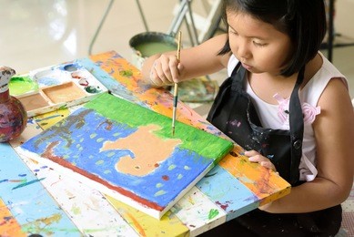 little asian girl love to painting dog on canvas with acrylic color in art school, children art