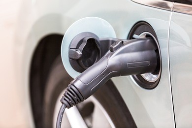 charging electric car in residential garage.