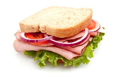 delicious ham sandwich with whole wheat bread on white back