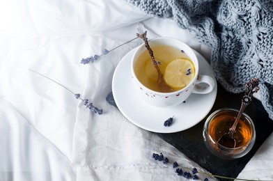 tray with honey and a cup of hot tea in the bed, lazy morning, warm winter mood