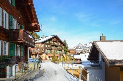traditional swiss house and alps mountains on background in murren, switzerland.