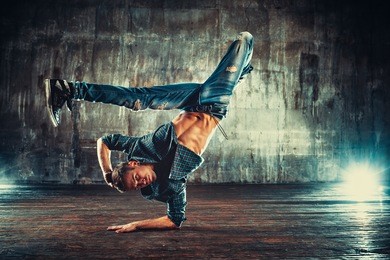 young man break dancing on old wall background
