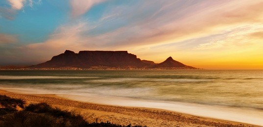 table mountain panoramic landscape with beautiful colorful sunset and streaking clouds landscape, cape town, south africa