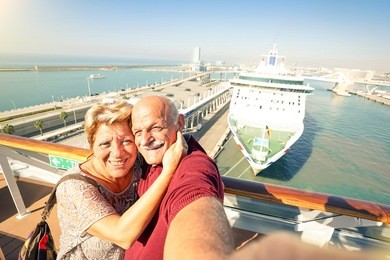 senior happy couple taking selfie on ship on harbor background - mediterranean cruise travel tour - active elderly concept with retired people around the world - bright sunny afternoon color tones