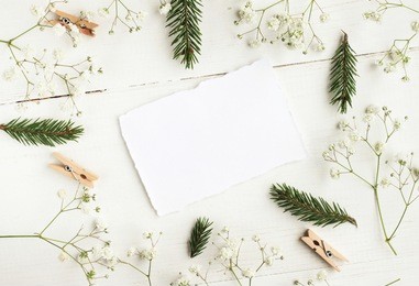 
craft paper writing background, framed flowers, pine tree twigs, decor festive mock up. light white and green tones, soft focus. place for text. 