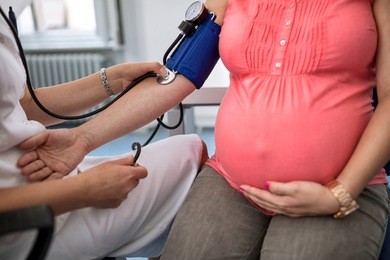 nurse measuring pressure of pregnant woman