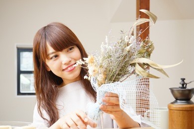 young asian woman arranging a dried flowers at home