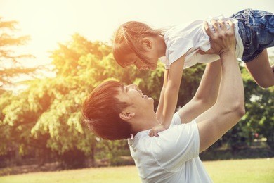 portrait of happy asian little girl with her father in the garden