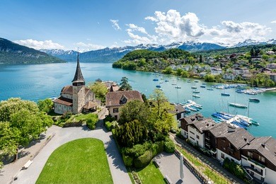 spiez castle with cruise ship on lake thun in bern, switzerland.