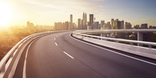 highway overpass motion blur with city background . sunrise scene .
