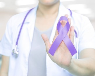 female doctor with lavender violet orchid awareness ribbon in hand for cancer awareness (all kinds),craniosynostosis,epilepsy,gynecological cancer
,hodgkin's lymphoma,national cancer prevention month