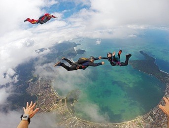 a happy group of skydivers above the beach