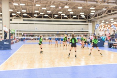 blurred image group of teen girls playing indoor volleyball. volleyball competition blur background. high school volleyball tournament concept.