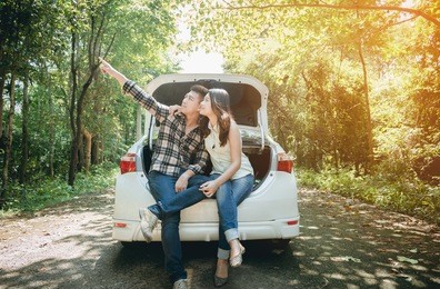 couple on road trip sit on convertible car. filtered image.