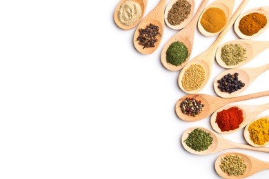 various spices in wooden spoons isolated on white background.