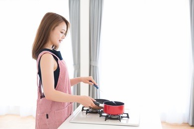 young attractive asian woman who cooks in a kitchen