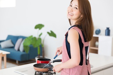young attractive asian woman who cooks in a kitchen