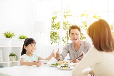 husband gives his wife  thumbs up for the delicious dinner 