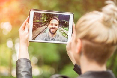 young couple in love chatting over a video call, by using a tablet. graded with a flare