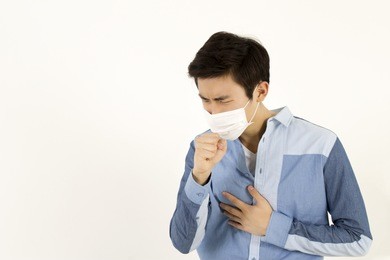 asian man wearing a face mask with coughing