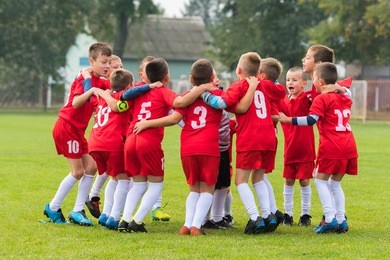 kids soccer team in group huddle