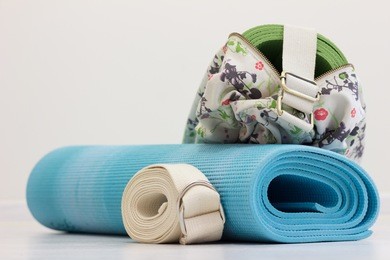 blue yoga mat, strap and green yoga mat in the bag lie on the floor