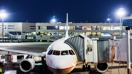 aircraft parked at the airport and preparation for next flight. loading cargo on the plane in airport terminal at night. workers cargo airplane service.