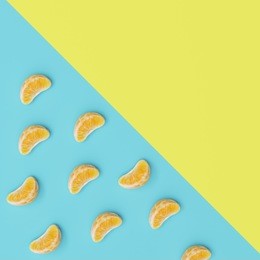creative concept, oranges petals on light blue and yellow pastel background, top view.