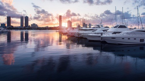 beautiful golden hour sunset in a marina with boats and yachts reflecting in the water and overlooking southport, main beach, gold coast, queensland, australia